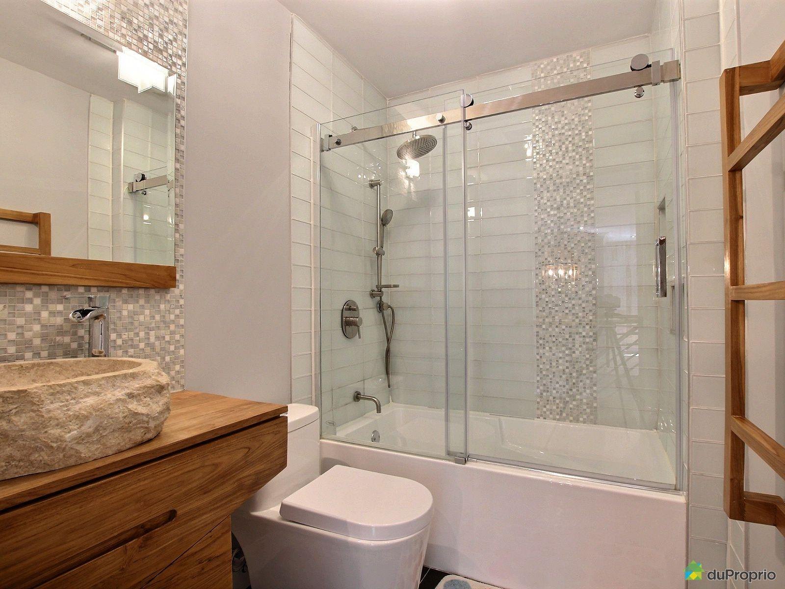 Salle de bain avec douche vitrée, carrelage blanc et vanité en bois