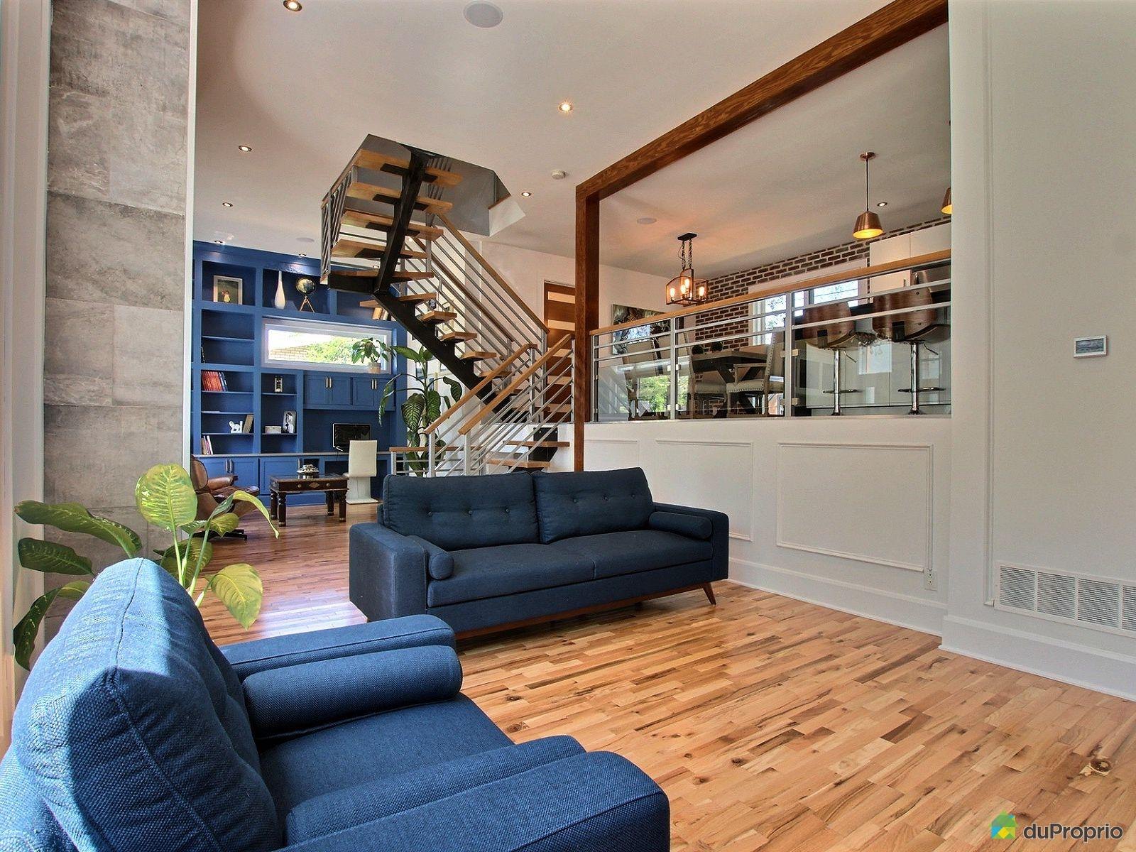 Salon ouvert avec escalier suspendu, éclairage encastré et luminaires suspendus au-dessus du comptoir