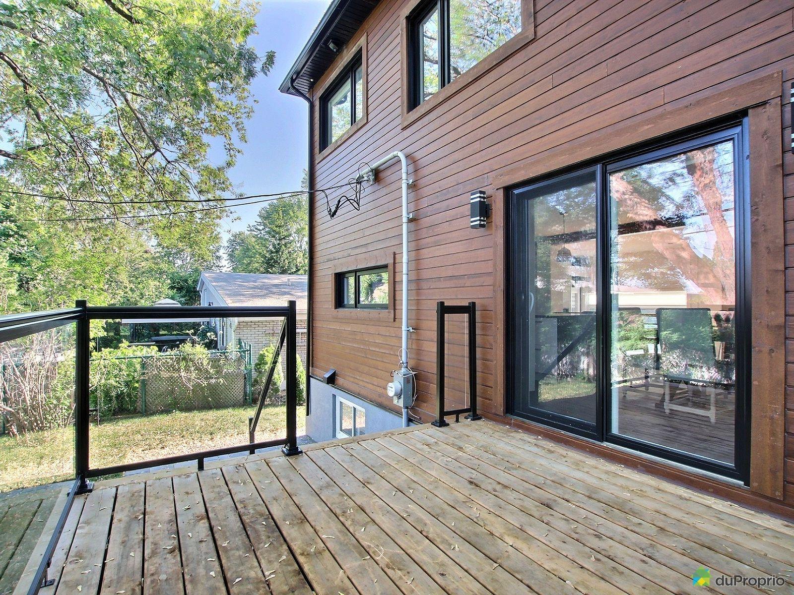 Arrière d’une maison avec terrasse et revêtement de bois